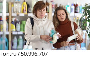 Two positive young and middle-aged women choosing body washcloth in retail store. Стоковое видео, видеограф Яков Филимонов / Фотобанк Лори