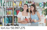 Woman with daughter choosing liquid soap in store. Стоковое видео, видеограф Яков Филимонов / Фотобанк Лори