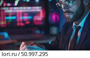 Focused man analyzes data in a neon-lit room during a late-night session. Стоковое AI-видео, аниматор Сергей Толмачёв / Фотобанк Лори