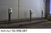 Electric Vehicle Charging Stations in a Dimly Lit Parking Area with Neon Green Lights Marking Their Presence and Readiness for Charging. Стоковое видео, видеограф Владимир Федоров / Фотобанк Лори