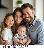 In a bright kitchen, a joyful family gathers for a cherished moment. Parents hold their children close, sharing smiles and warmth as love radiates throughout the space Generative AI. Стоковое AI-изображение, AI-художник Юлия Петровская / Фотобанк Лори