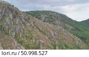 Scenic landscape featuring steep mountains and dense forests in a valley, with dramatic cloud formations above, highlighting the tranquility of the natural environment. Стоковое видео, видеограф Ирина Ручушкина / Фотобанк Лори