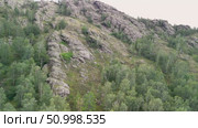 Scenic landscape featuring steep mountains and dense forests in a valley, with dramatic cloud formations above, highlighting the tranquility of the natural environment. Стоковое видео, видеограф Ирина Ручушкина / Фотобанк Лори