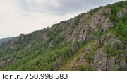 Scenic landscape featuring steep mountains and dense forests in a valley, with dramatic cloud formations above, highlighting the tranquility of the natural environment. Стоковое видео, видеограф Ирина Ручушкина / Фотобанк Лори