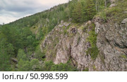 Scenic landscape featuring steep mountains and dense forests in a valley, with dramatic cloud formations above, highlighting the tranquility of the natural environment. Стоковое видео, видеограф Ирина Ручушкина / Фотобанк Лори