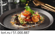 Sliced tomatoes resting atop quinoa, sprinkled with fresh herbs, accompanied by creamy dollop on textured ceramic plate, highlighting vibrant vegetarian gourmet styling. Стоковое AI-видео, аниматор Данил Руденко / Фотобанк Лори