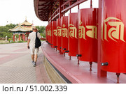 A tourist turns prayer drums of khurul, Buddhist temple Golden Abode of Buddha Shakyamuni, largest Buddhist temple in Europe, Elista, Kalmykia, Russia, July, 4, 2025. Редакционное фото, фотограф Екатерина Топорова / Фотобанк Лори