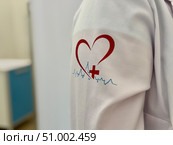 A medical officer in a white coat with a logo in Moscow. Редакционное фото, фотограф Соболева Наталия / Фотобанк Лори