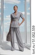 Elegant businesswoman posing in gray suit with handbag. Стоковое AI-видео, аниматор Юрий Поздников / Фотобанк Лори