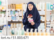 Young Muslim woman customer scanning QR-code on paracetamol box. Стоковое фото, фотограф Яков Филимонов / Фотобанк Лори