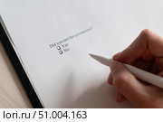 A woman puts a daw in the questionnaire. Close-up of a female hand answering a question about a coronovirus. Did you test for coronavirus. Стоковое фото, фотограф Михаил Решетников / Фотобанк Лори