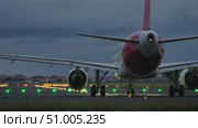 Airplane on runway with lights glowing in the background during twilight hours showcasing aviation. Стоковое видео, видеограф Данил Руденко / Фотобанк Лори