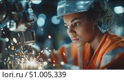 Young woman welding in a manufacturing facility during evening hours showcases skill and determination. Стоковое AI-видео, аниматор Сергей Толмачёв / Фотобанк Лори