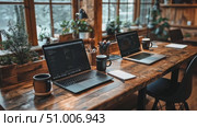 Explore a warm and inviting workspace featuring laptops, coffee mugs, and greenery in a rustic cabin as winter sunlight streams through the windows. Стоковое AI-видео, аниматор Данила Большаков / Фотобанк Лори