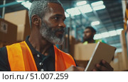 Warehouse worker inspects supplies and ensures safety protocols in bustling distribution center. Стоковое AI-видео, аниматор Сергей Толмачёв / Фотобанк Лори
