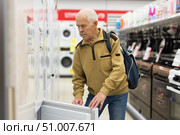 elderly man choosing refrigerator in showroom of electrical appliance store. Стоковое фото, фотограф Татьяна Яцевич / Фотобанк Лори