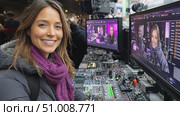 A lively broadcast unfolds as a presenter interacts with the crew and equipment amidst a bustling city atmosphere. Стоковое AI-видео, аниматор Данила Большаков / Фотобанк Лори