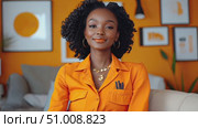 A fashionable woman dressed in an orange outfit discusses her favorite creative projects in a bright, art-filled living area that inspires creativity. Стоковое AI-видео, аниматор Данила Большаков / Фотобанк Лори