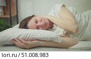 Young adult woman wakes up in the morning in bed and suffers from neck pain. Concept of problems with the spine due to improperly fitted pillow. Стоковое видео, видеограф Денис Кебедов / Фотобанк Лори