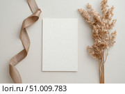 Blank greeting card, invitation mockup. Dry grass, pampas plant on beige table background. Flat lay, top view. Copyspace. Paper cards, mock up. Modern Minimal business brand template. Soft shadow. A6. Стоковое AI-изображение, AI-художник Марина Демидюк / Фотобанк Лори