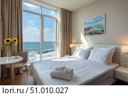 Clean bed. Light bedroom. Modern apartment interior. White sheet, soft pillow, blanket. Sea view, ocean. Home, hotel stylish design. Comfortable grey bedding set closeup. Spa resort ad. Rent business. Стоковое AI-изображение, AI-художник Марина Демидюк / Фотобанк Лори