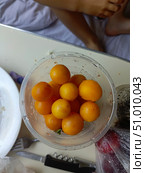 Yellow cherry tomatoes in a clear bowl in a high-angle, casual style representing fresh ingredients and healthy snacking. Стоковое фото, фотограф Елена Высокова / Фотобанк Лори