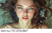 A young woman with captivating blue eyes and long hair poses underwater, creating a serene and enchanting atmosphere filled with bubbles. Стоковое AI-видео, аниматор Данила Большаков / Фотобанк Лори