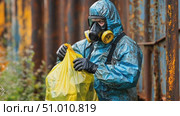 A worker in protective gear collects hazardous waste in an abandoned industrial region while ensuring safety protocols are followed. Стоковое AI-видео, аниматор Данила Большаков / Фотобанк Лори