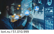 An analyst engages with an interactive digital dashboard, analyzing data trends and metrics in a contemporary office environment during evening hours. Стоковое AI-видео, аниматор Данила Большаков / Фотобанк Лори