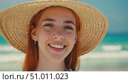 Charming redhead woman in straw hat relaxing at seaside resort in tropical country. Smiling young woman with freckles by ocean. Portrait of female model with clean smooth skin. Close-up, portrait. Стоковое AI-видео, аниматор Ирина / Фотобанк Лори