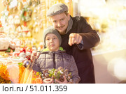 Man with son stands in middle of shopping area decorated for New Year holidays. Стоковое фото, фотограф Яков Филимонов / Фотобанк Лори