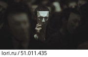 Crowd wearing plain masks engages in mysterious gathering during night event in urban setting. Стоковое AI-видео, аниматор Сергей Толмачёв / Фотобанк Лори