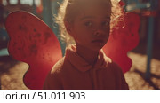 Joyful child with butterfly wings enjoys playful moments at a park in the golden hour. Стоковое AI-видео, аниматор Сергей Толмачёв / Фотобанк Лори