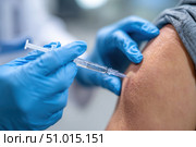 Doctor making a vaccination. Cropped of man receiving vaccine shot. Hands injecting coronavirus vaccine syringe to arm muscle of patient. Covid 19 immunization. Mpox, Dengue fever, Chikungunya. CHIKV. Стоковое AI-изображение, AI-художник Марина Демидюк / Фотобанк Лори