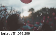 Joyful moments shared between mother and child with a pink balloon at sunset in a lively park. Стоковое AI-видео, аниматор Сергей Толмачёв / Фотобанк Лори
