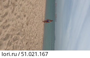 A 50-year-old European woman in a swimsuit walks along the beach in Doha, Qatar. Стоковое видео, видеограф IRYNA ZAKHARANKA / Фотобанк Лори