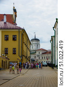 A group of people is walking along the street of an old European city. Belarus. Minsk. 05.08.25. Редакционное фото, фотограф Ярославский Максим / Фотобанк Лори