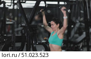 Fit woman in mid-thirties training in contemporary fitness center, using lat pulldown machine to strengthen upper body muscles, embracing active and health-conscious lifestyle. Стоковое видео, видеограф Яков Филимонов / Фотобанк Лори