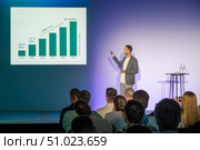 Speaker delivering business presentation with graph to seated audience attendees. Стоковое фото, фотограф Антон Гвоздиков / Фотобанк Лори