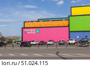 Magnitogorsk, Russian Federation - August 05, 2025: "Tetris" Colorful shopping center with vibrant storefronts and busy street traffic, showcasing urban lifestyle and commercial activity in a lively city environment. Редакционное фото, фотограф Ирина Ручушкина / Фотобанк Лори