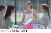 Athletic women stand near the net on the court, hold rackets and chat in between playing paddle tennis. Стоковое видео, видеограф Яков Филимонов / Фотобанк Лори