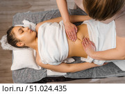 Slim young woman receiving stomach massage in spa salon. Стоковое фото, фотограф Владислав Тригуб / Фотобанк Лори