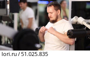 Bearded man in gym performs exercises for arm muscles using simulators and fitness center equipment. Стоковое видео, видеограф Яков Филимонов / Фотобанк Лори