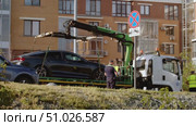 Traffic police officer uses tow truck to evacuate car that is parked in prohibited place, under No Stopping sign, on side of road in city. Стоковое видео, видеограф Strunov David / Фотобанк Лори