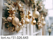 Delicate wreath of golden Christmas decorations hangs on the white wall. Magic and joy festive celebrations during the winter season. Elegant gold and silver Ornaments beautifully decorated setting. Стоковое AI-изображение, AI-художник Марина Демидюк / Фотобанк Лори