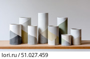 Modern ceramic vases displaying artistic elegance on wooden shelf. Стоковое AI-изображение, AI-художник Юрий Поздников / Фотобанк Лори