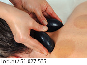 Close-up of hot stone massage on neck and shoulder area in spa therapy session. Стоковое фото, фотограф Raquel Corcoles Mendez / Фотобанк Лори