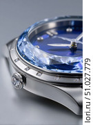 Luxury wristwatch with blue crystal and diamonds sparkling on grey background. Стоковое AI-изображение, AI-художник Юрий Поздников / Фотобанк Лори