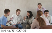 Exited adult students engaged in discussion sitting on chairs in circle in light room. Стоковое видео, видеограф Яков Филимонов / Фотобанк Лори