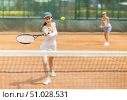 Woman playing tennis against female opponent on tennis court. Стоковое фото, фотограф Яков Филимонов / Фотобанк Лори